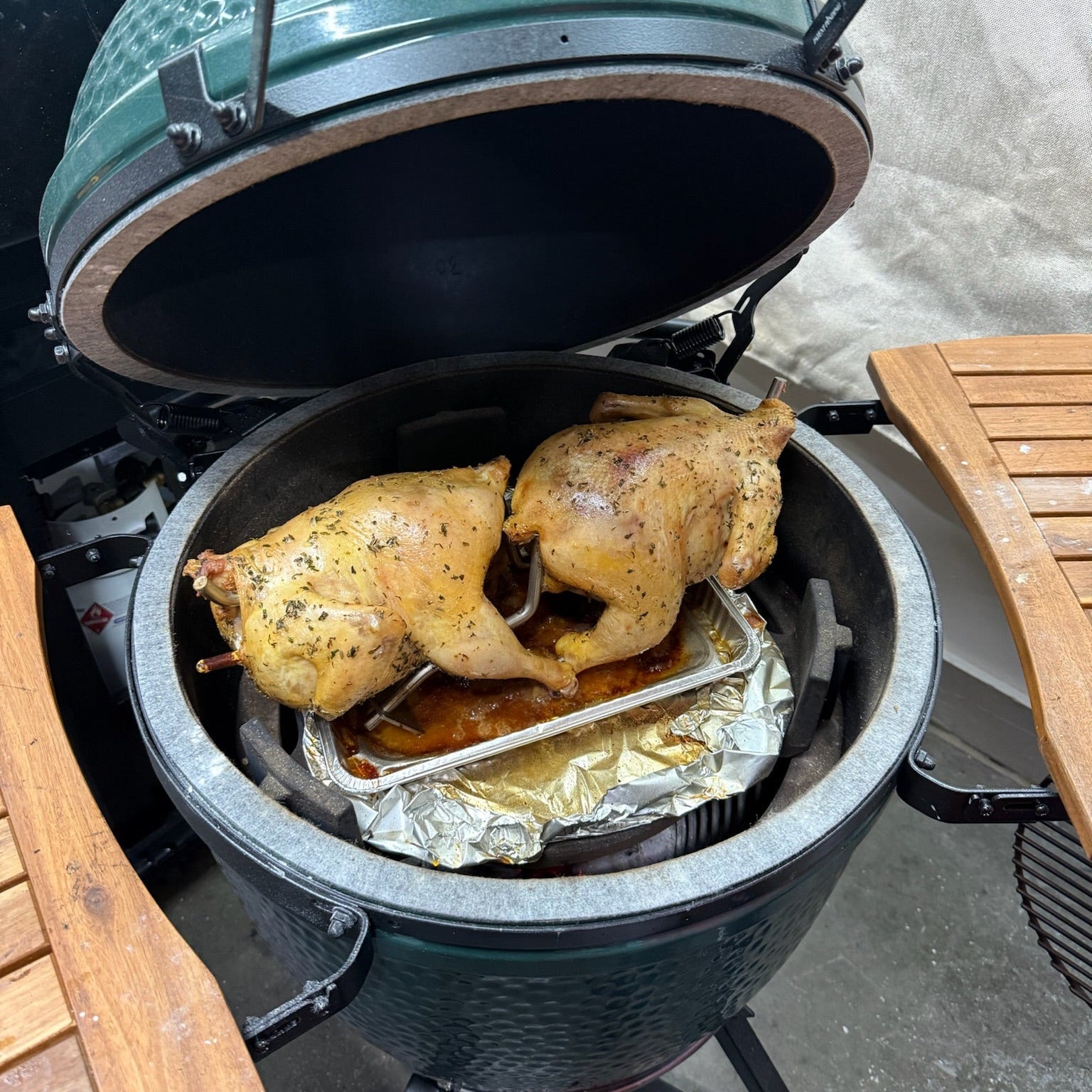 Big Green Egg grill with chicken cooking inside